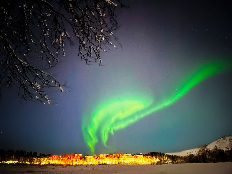 Polarlichter-ueber-leuchtender-Stadt